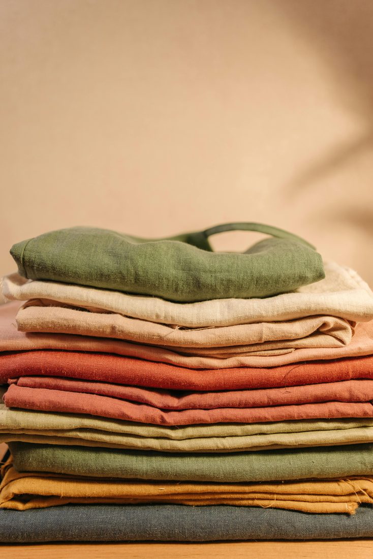 Neatly folded stack of textiles in warm tones